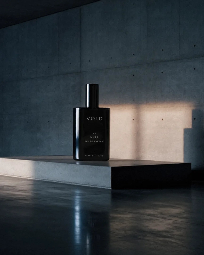 El frasco negro de VOID 01 NULL sobre un pedestal de hormigón en una sala vacía